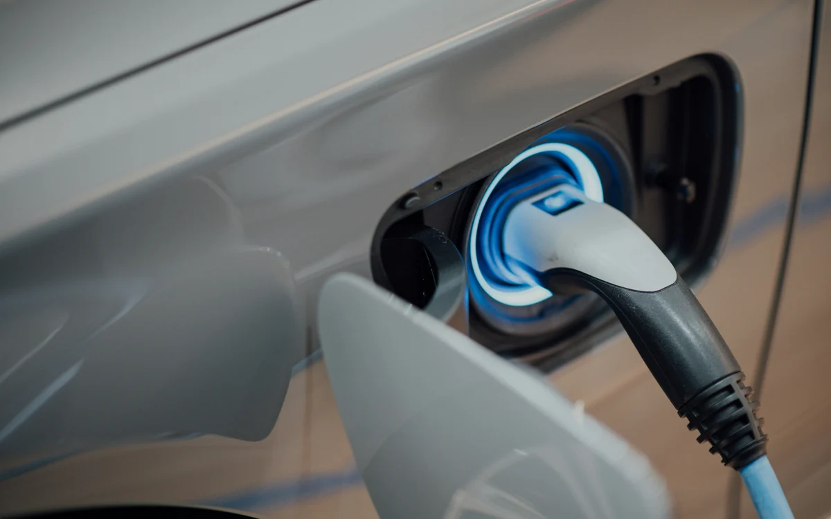 Wtyczka do ładowania włożona w gniazdo samochodu elektrycznego